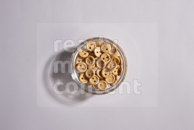 Colored buttons in a glass bowl on grey background