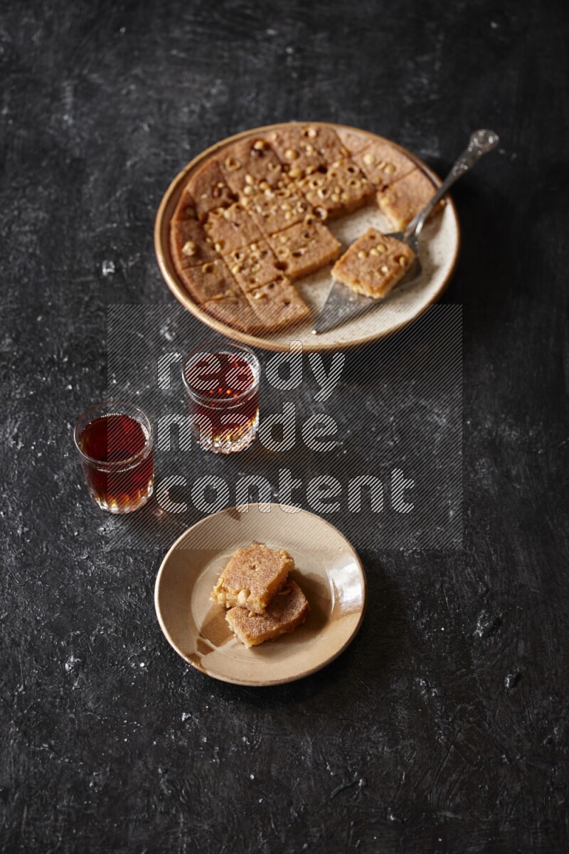 بسبوسة مع الشاي علي خلفية سوداء خشبية