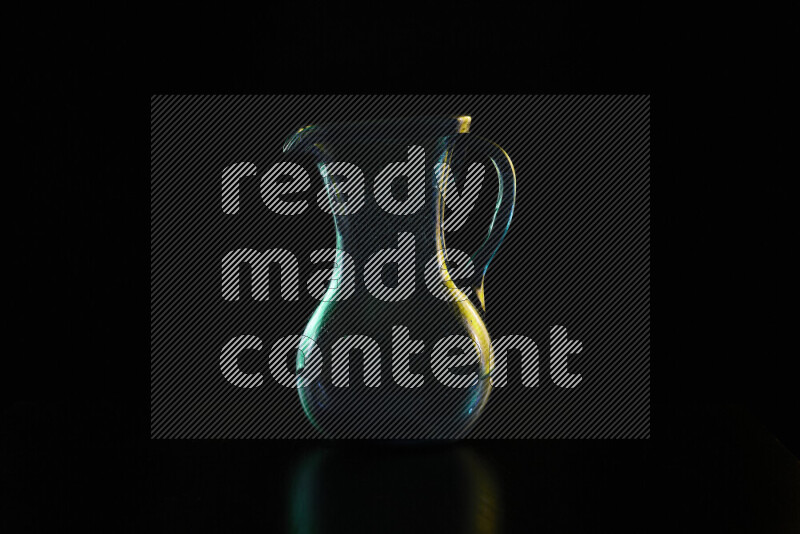 Glassware with rim light in green and yellow against black background