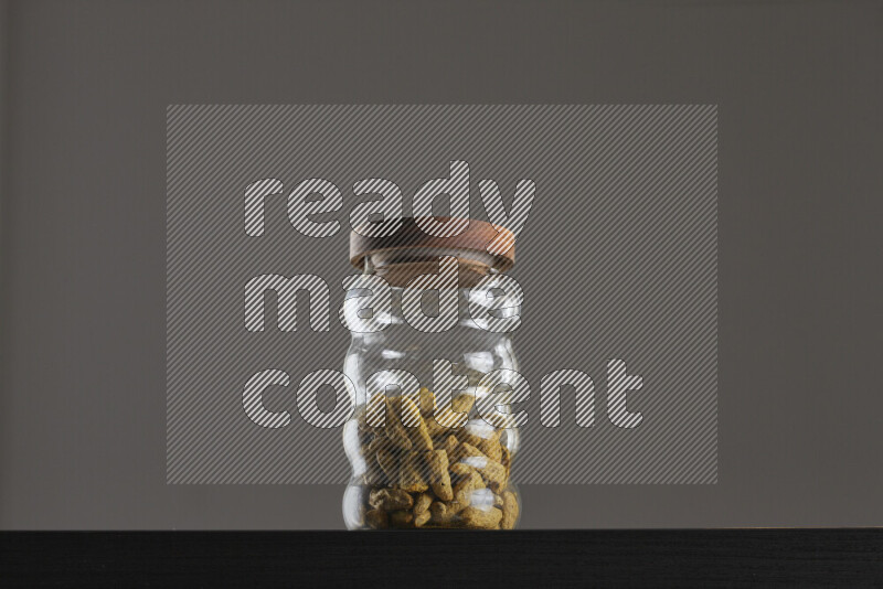 Turmeric in a glass jar on black background