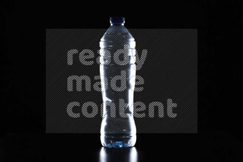 Water bottle with colored rim light against black background