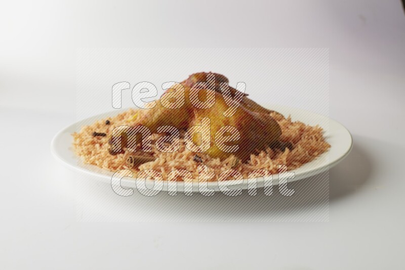 red basmati Rice with kabsa chicken pieces on a white rounded plate direct on white background