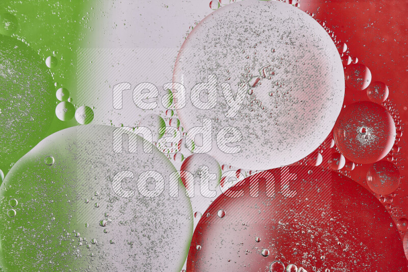 Close-ups of abstract oil bubbles on water surface in shades of red, green and white