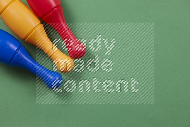 Multicolored plastic bowling pins on different colored backgrounds background (kids toys)