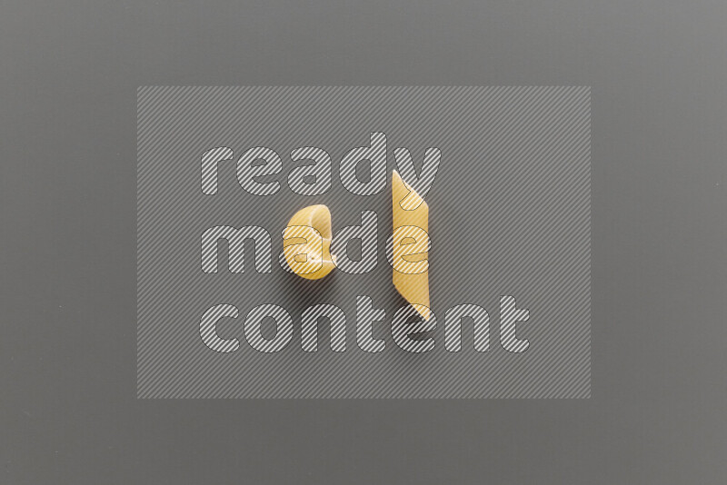 Pipe pasta with other types of pasta on grey background