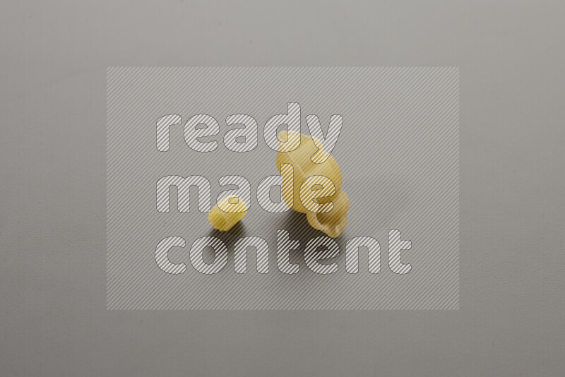 Small rings pasta with other types of pasta on grey background