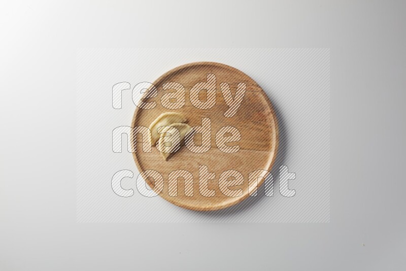 Two Sambosas on a wooden round plate on a white background