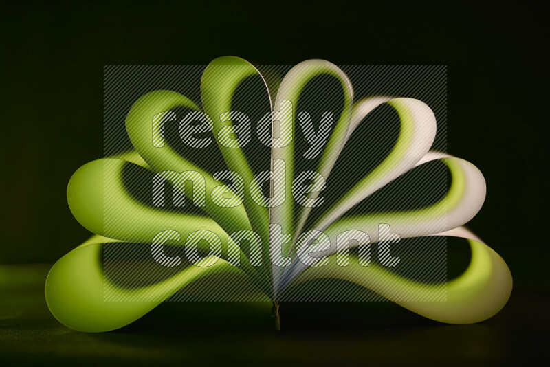 An abstract art piece displaying smooth curves in green gradients created by colored light