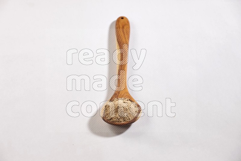 A wooden ladle full of garlic powder on a white flooring in different angles