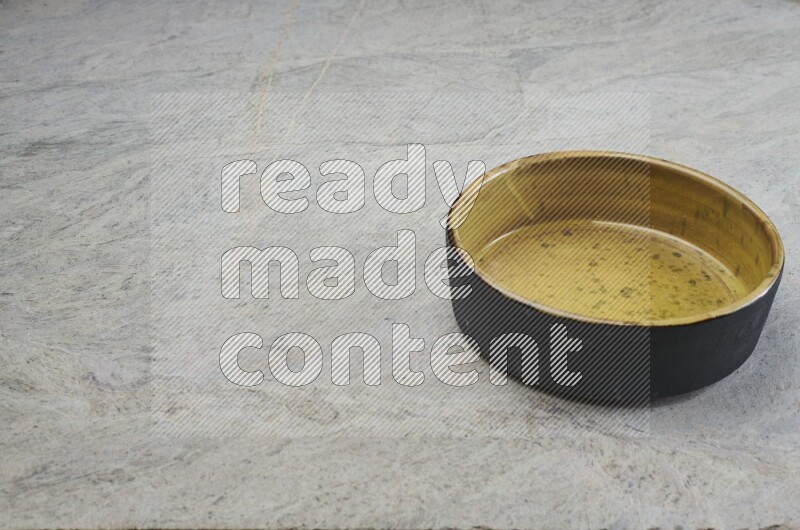 A multicolored pottery oven plate on grey marble background