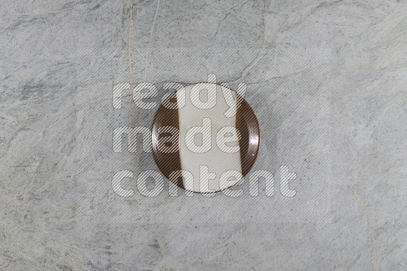 Top View Shot Of A Multicolored Pottery Plate On Grey Marble Flooring