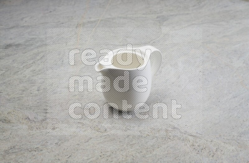 A ceramic milk jug on grey marble background