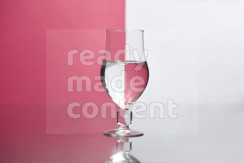 The image features a clear glassware filled with water, set against white and pink background