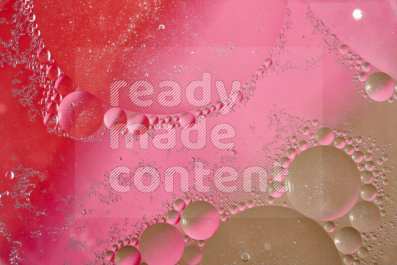 لقطات مقربة لفقاعات من الزيت على سطح الماء باللون البني والأحمر والوردي