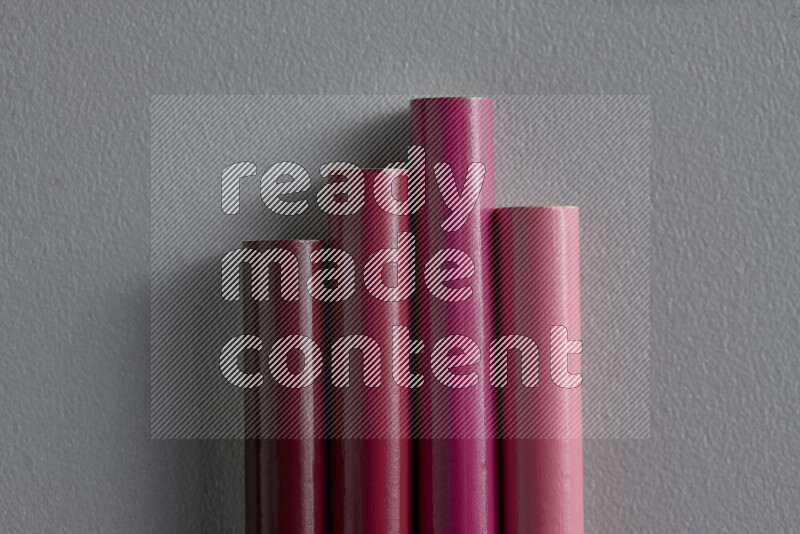 مجموعة من أقلام الرصاص الملونة مرتبة لتعرض تدرجا من الألوان الوردية علي خلفية رمادية