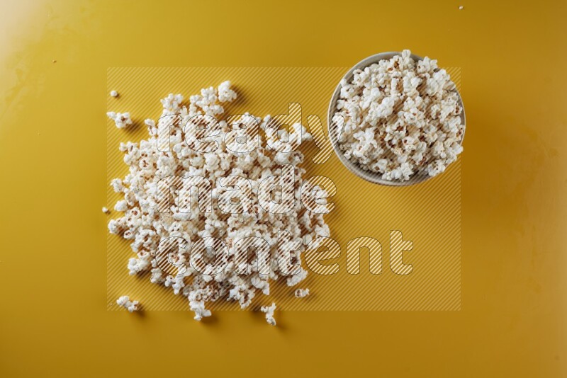 A white pottery bowl full of popcorn with popcorn beside it on a yellow background in different angles