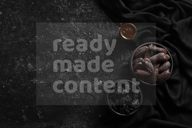 فواكه مجففة في أطباق فخارية مع القهوة علي خلفية سوداء خشبية