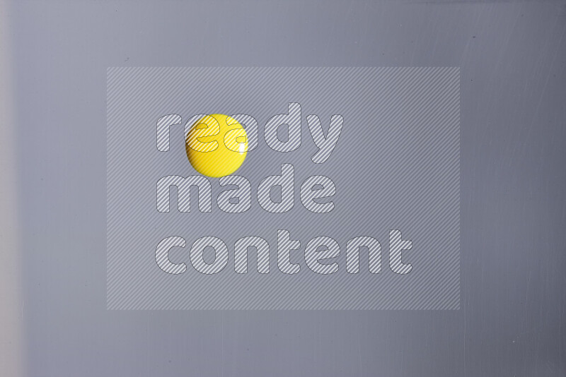 Close-ups of abstract yellow paint droplets on grey background