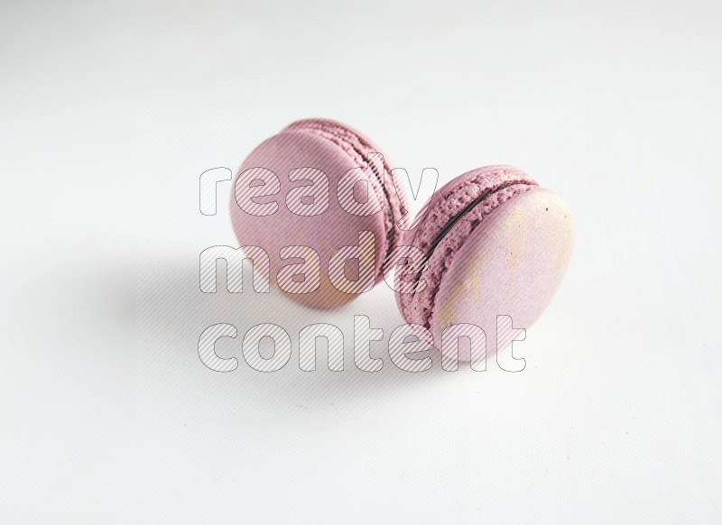 45º Shot of two Purple Strawberry macarons on white background