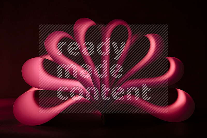 An abstract art piece displaying smooth curves in red gradients created by colored light