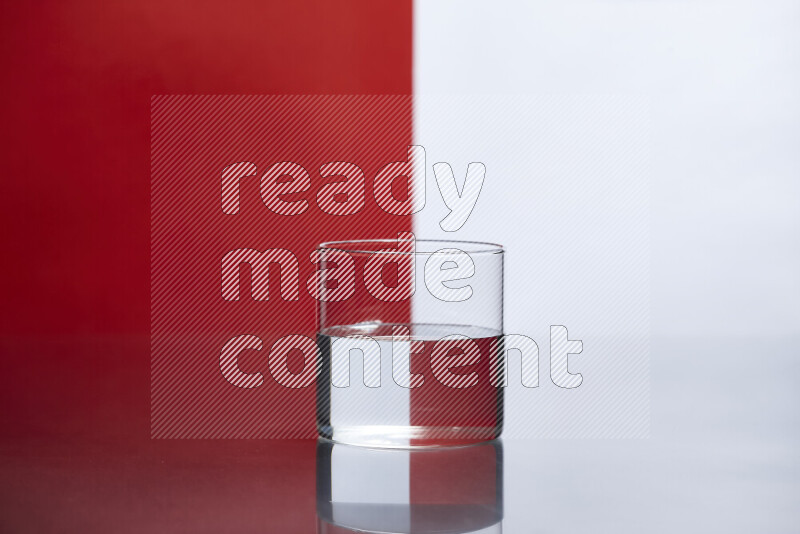 The image features a clear glassware filled with water, set against white and red background