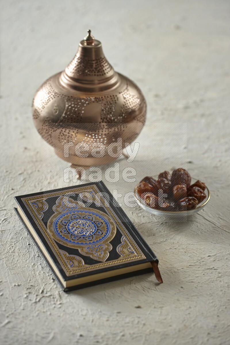 A golden lantern with different drinks, dates, nuts, prayer beads and quran on textured white background