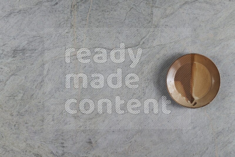 A multicolored pottery plate on grey marble background