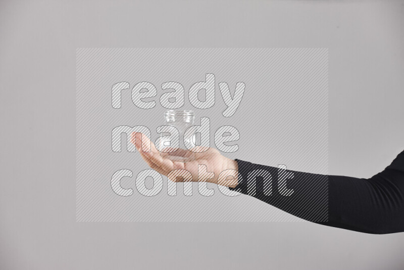 امرأة ترتدي عباءة سوداء تحمل أدوات زجاجية مختلفة في أوضاع متعددة