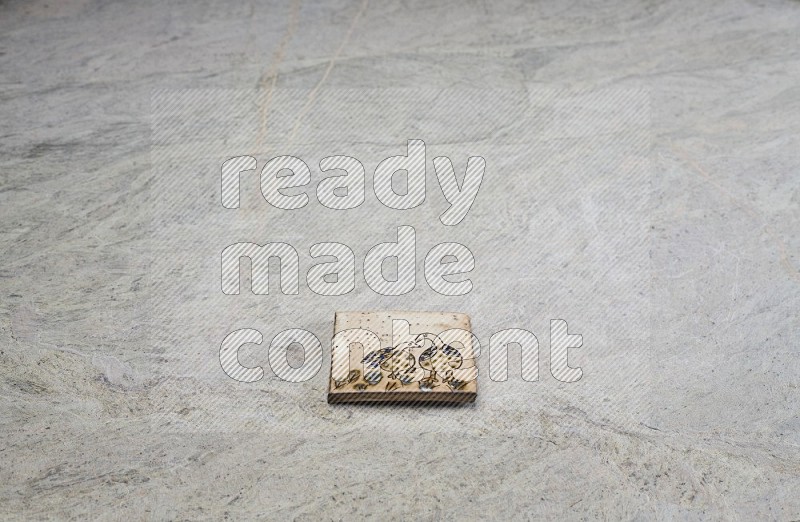 Top view shot of a pottery coaster\ tile on beige marble flooring