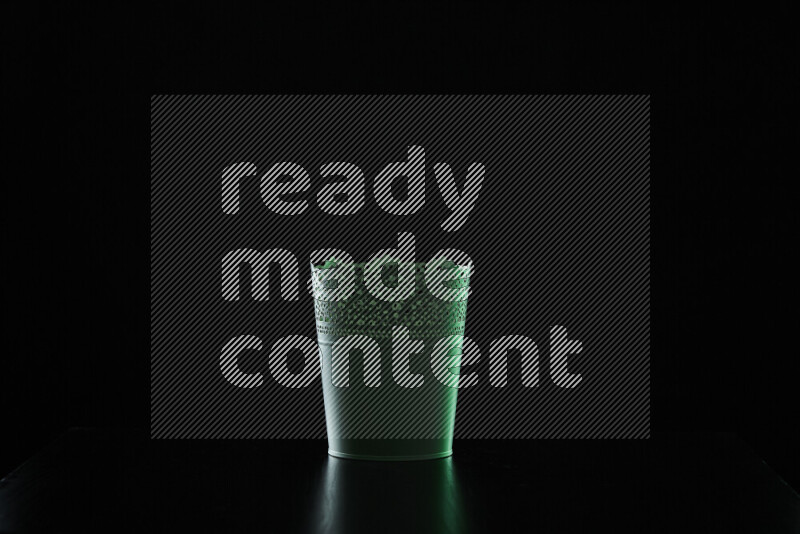 A plant pot with colored rim light against black background