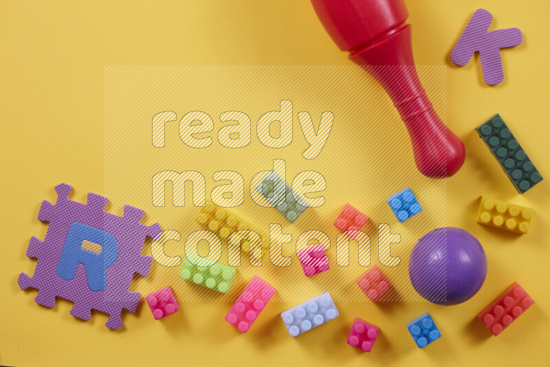 Plastic building blocks, balls and bowling pins on different colored backgrounds (kids toys)