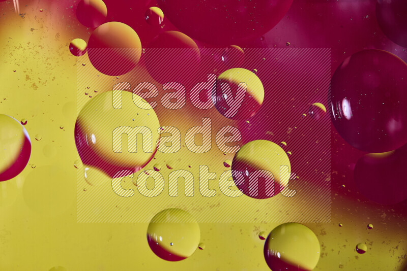Close-ups of abstract oil bubbles on water surface in shades of red and yellow