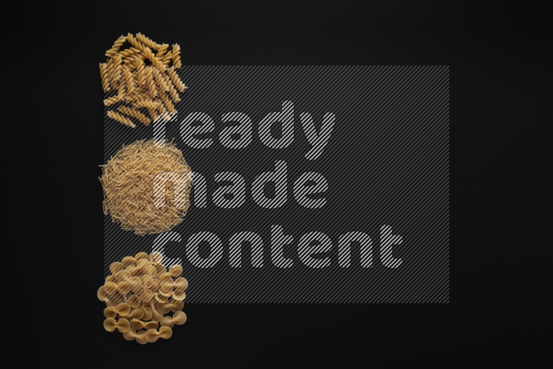 Different pasta types in 3 bunches on black background