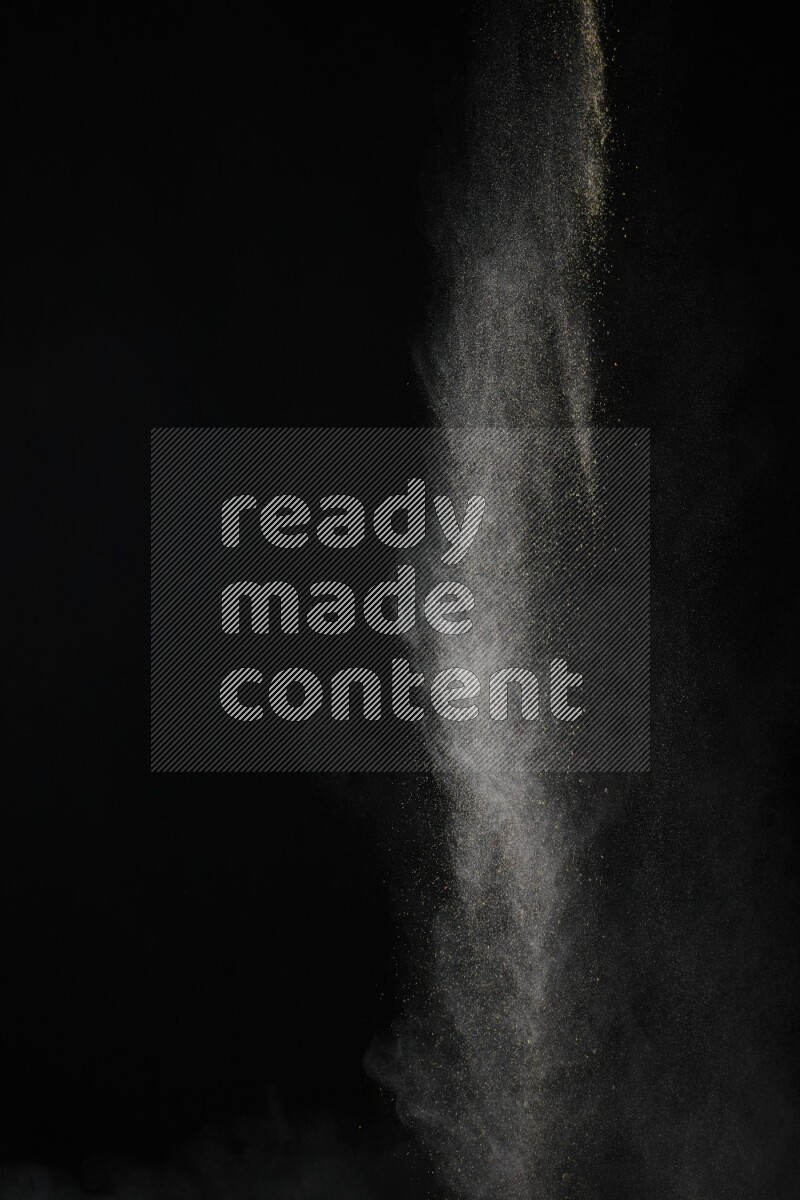 A side view of brown powder explosion on black background