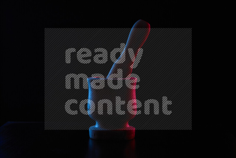 Wooden kitchen essentials with colored rim light against black background