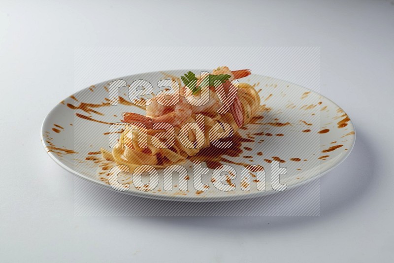 Fettuccini red sauce pasta with shrimp in a white plate on a white background