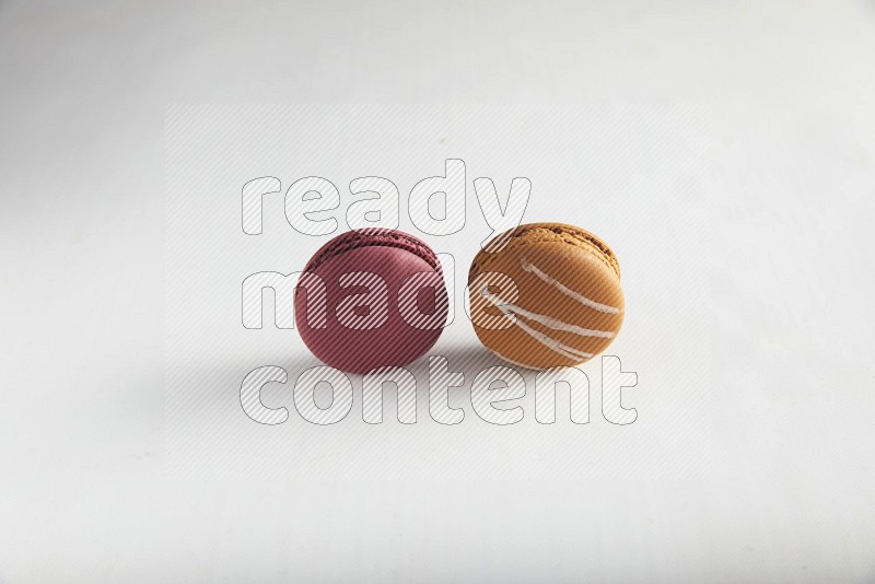 45º Shot of of two assorted Brown Irish Cream, and Red Cherry macarons on white background