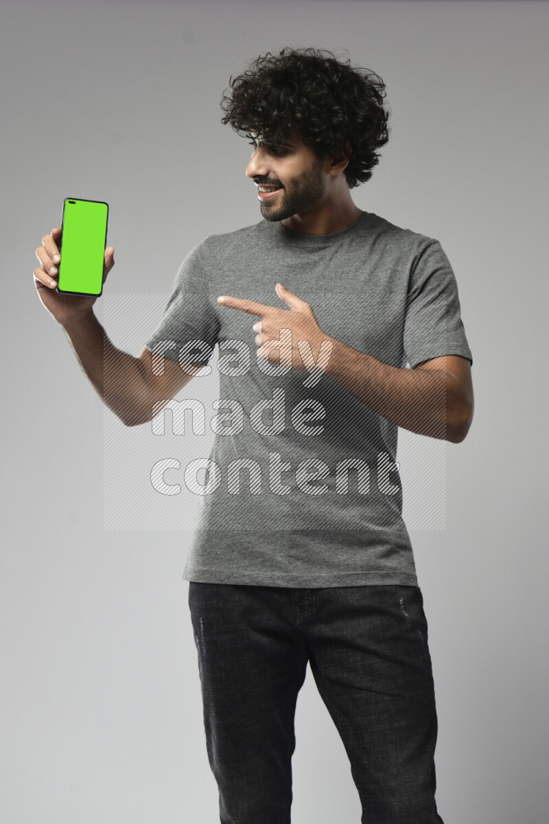 A man wearing casual standing and showing a phone screen on white background