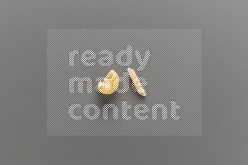 Pipe pasta with other types of pasta on grey background