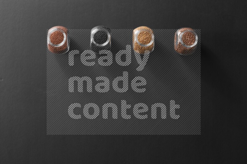 حبة البركة و حبوب الخردل وحبوب الكتان وحب الرشاد في أوعية زجاجية علي خلفية سوداء