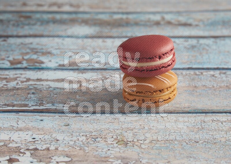 45º Shot of of two assorted Brown Irish Cream, and Red Velvet macarons on light blue background