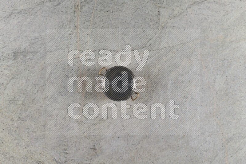 A small copper pot on grey marble background