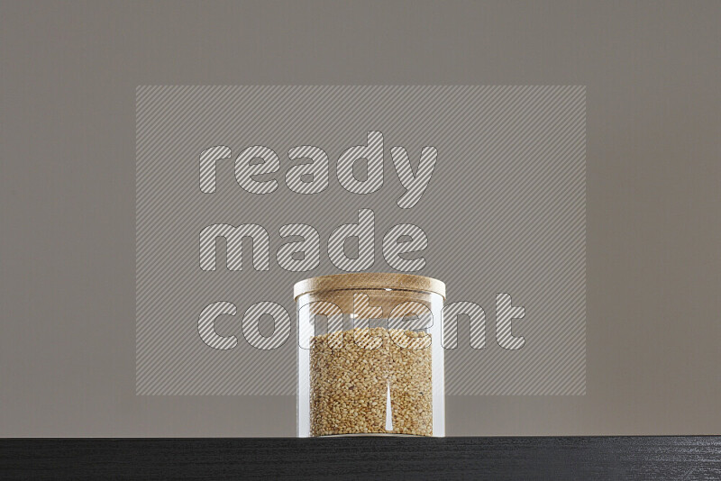 Sesame in a glass jar on black background