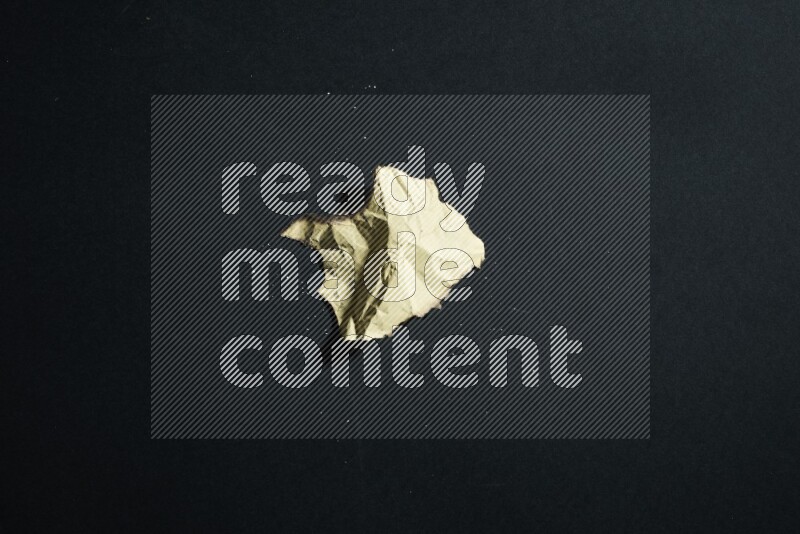 Burnt multicolored paper on black background