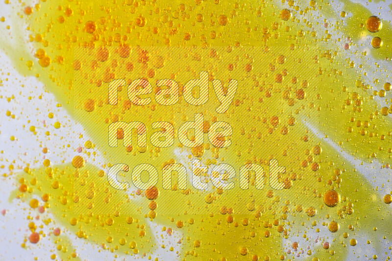 لقطات مقربة لقطرات ألوان مائية صفراء وحمراء على سطح الزيت على خلفية بيضاء