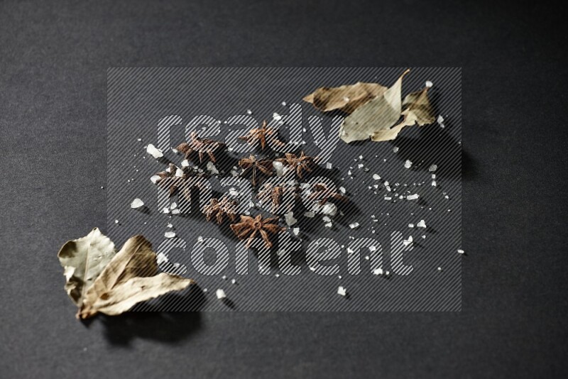 الملح واليانسون النجمي وورق الغار على خلفية سوداء