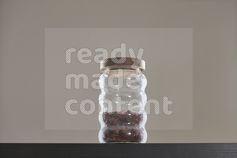 Sequins in a glass jar on black background