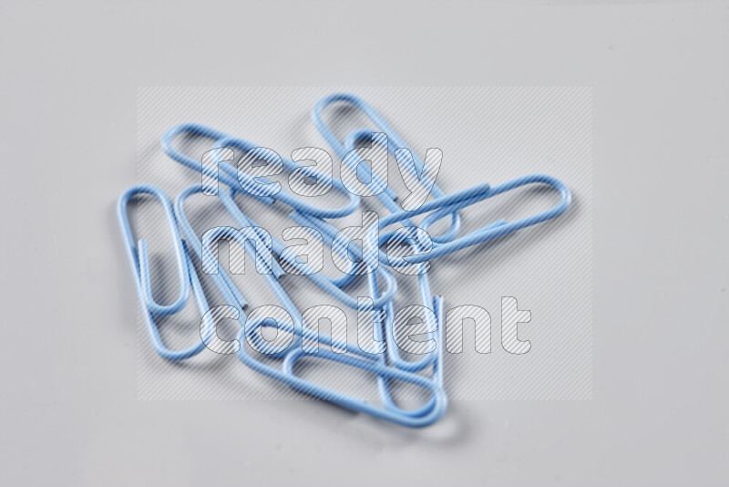 Blue paper clips isolated on a grey background