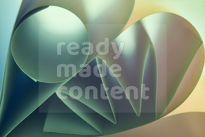 An artistic display of paper folds creating a harmonious blend of geometric shapes, highlighted by soft lighting in green and warm tones
