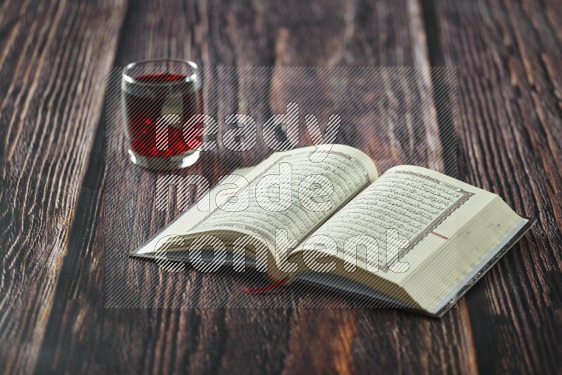 Quran with dates, prayer beads and different drinks all placed on wooden background